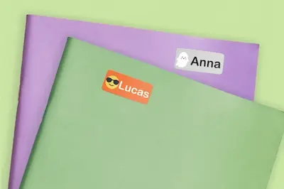 Cadernos roxo e verde com etiquetas de nome Anna e Lucas